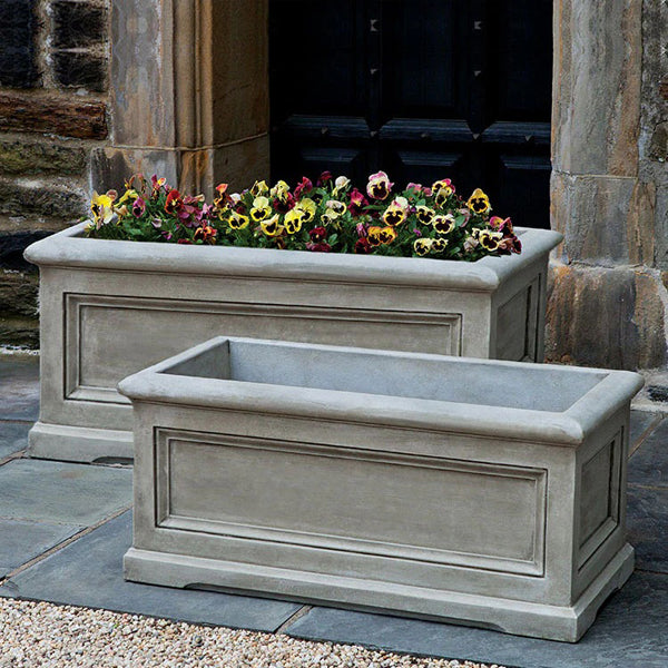 Best Selling Planters Collection image of Orleans Window Box Planter Large on concrete filled with flowers.