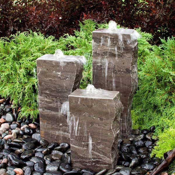 Blue Thumb Fountains Collection image of Rough Blue Limestone Fountain in action in backyard.