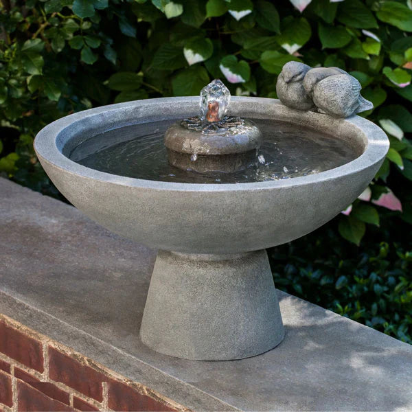 Small Outdoor Fountains Collection Image of Paradiso Fountain on ledge against green leaves.