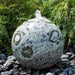 16 Inch Green Marble Sphere Fountain on black pebbles in the backyard