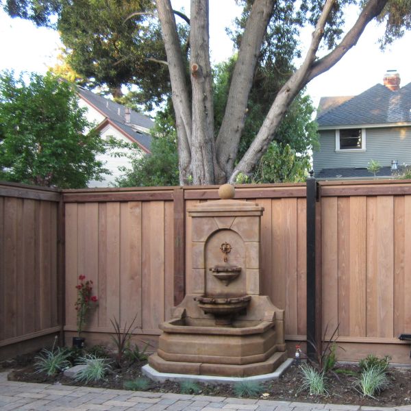 Acquitaine Wall Fountain in action against wooden fence.