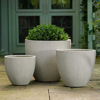 Airy Planter, Large - Alabaster Lite on concrete filled with plants