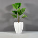 Alicante Tapered Fluted Round Fiberglass Planter on concrete filled with plants.
