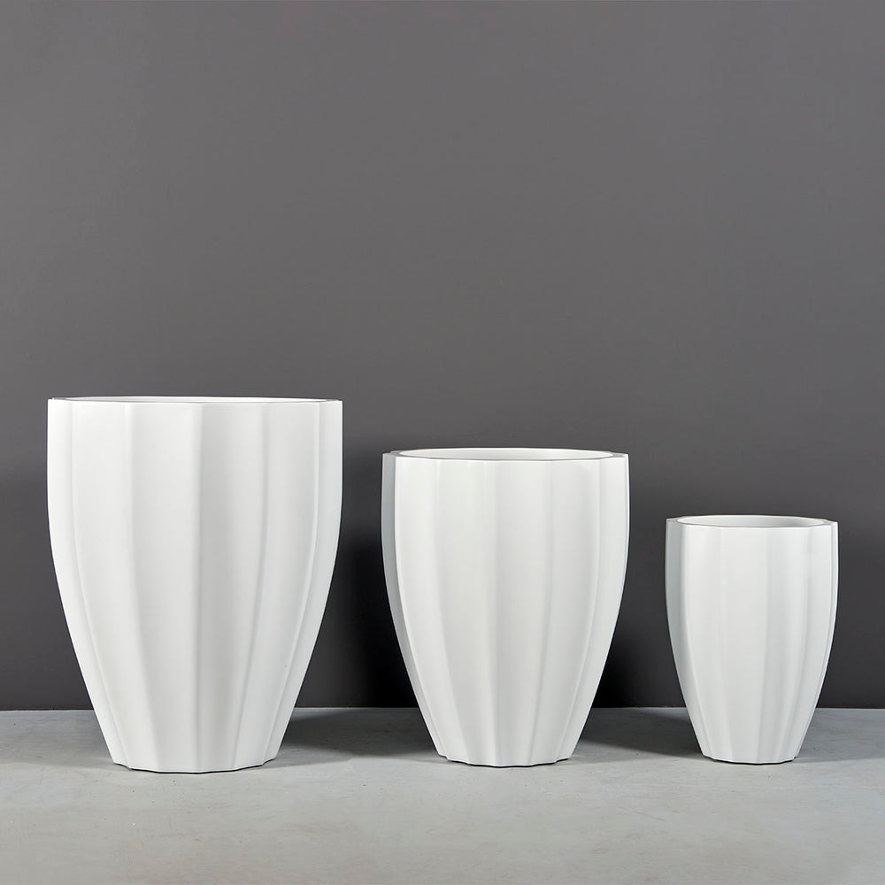 Alicante Tapered Fluted Round Fiberglass Planter on concrete shown with different sizes.