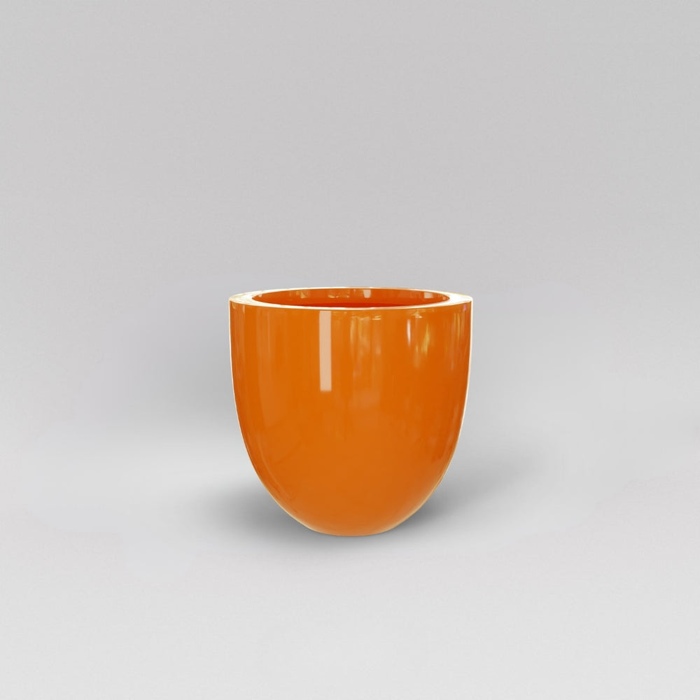 Alzira Round Fiberglass Planter in gloss tangerine against gray background.