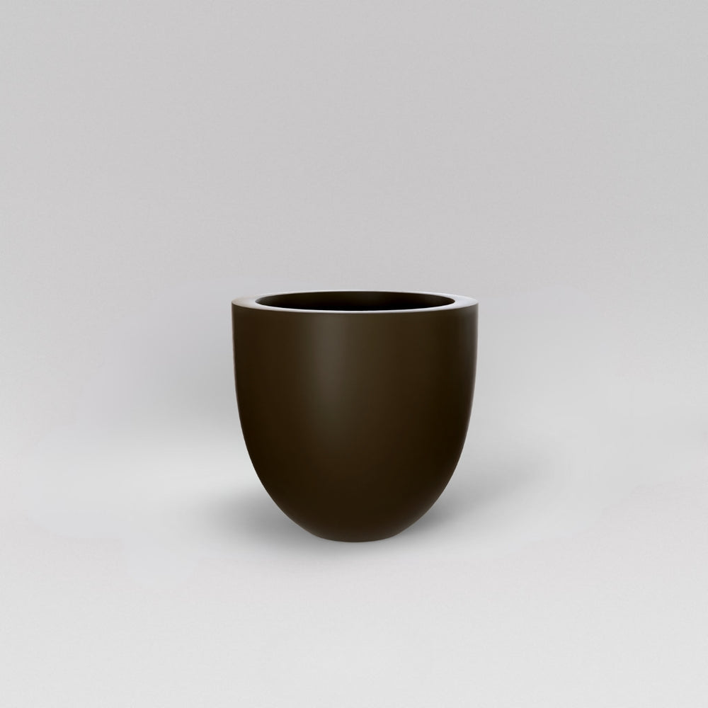 Alzira Round Fiberglass Planter in matte bronze against gray background.
