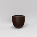 Alzira Round Fiberglass Planter in matte dark brown against gray background.