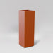 Amesbury Tall Corner Planter in matte terra cotta against gray background.