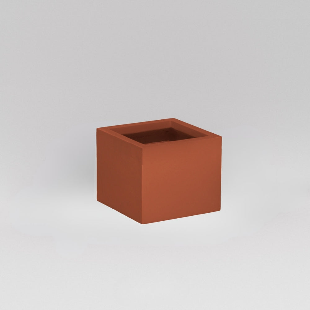 Antwerp Corner Fiberglass Planter in matte terra cotta against gray background.