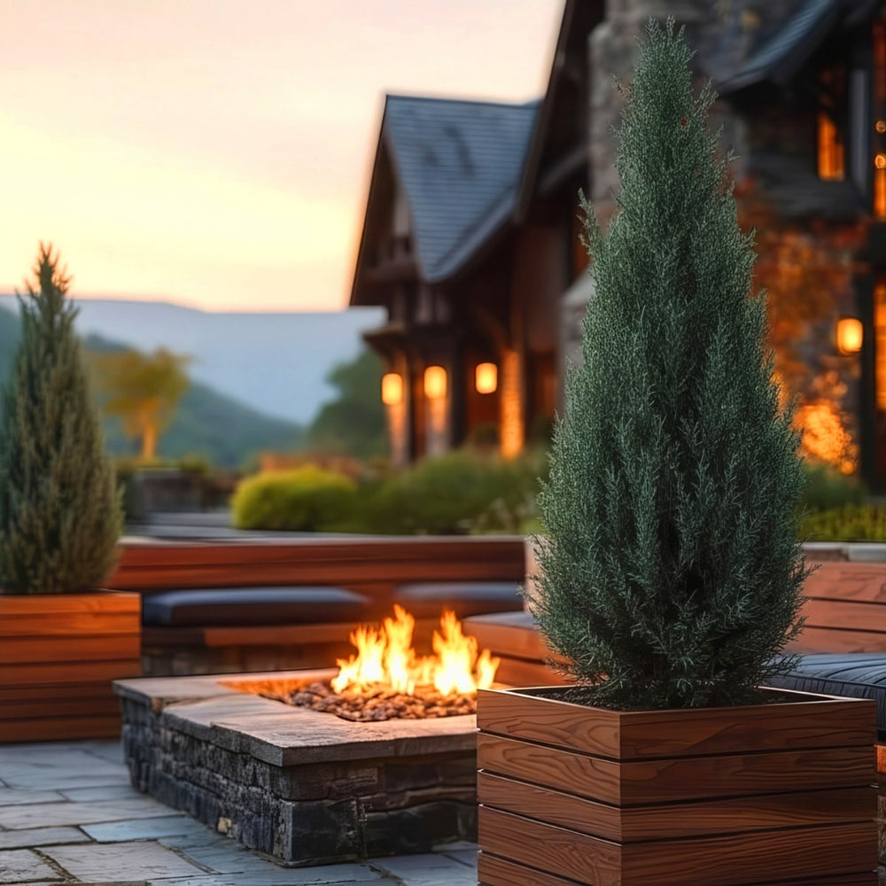 Asheville Cube Wood Look Fiberglass Planter filled with plants beside a fireplace.