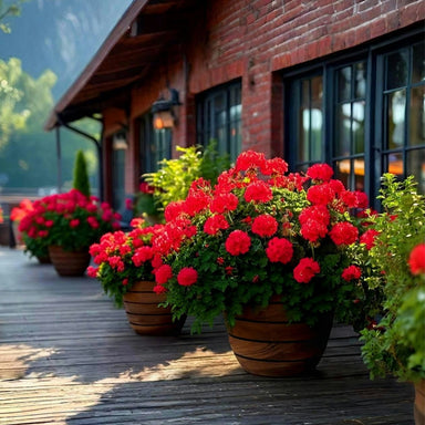 Aspen Round Wood look fiberglass planter filled with red flowers beside the house.