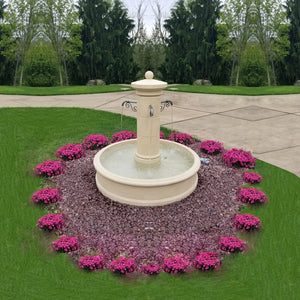 Avignon Outdoor Fountain in action on gravel pad surrounded by pink flowers
