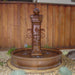 Avignon Pond Fountain in action against wooded fence.