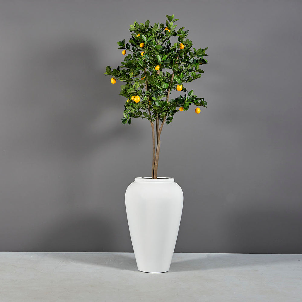 Bara Jar Tall Tapered Fiberglass Planter on concrete filled with plants.