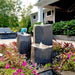 Basalt Bird Bath Fountain Kit in action beside pink flowers