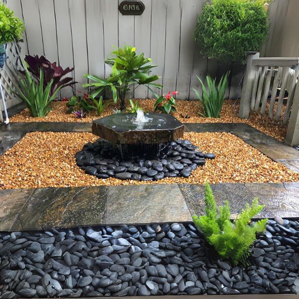 Basalt Bird Bath Fountain Kit on black peebels in the backyard