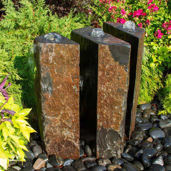 Basalt Fountain Kit 24 Triple Slit polished 3 piece on black pebbles in the backyard