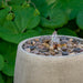 Bebel Pebble Fountain, Tall on gravel in the backyard upclose.