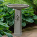 Birdhouse Birdbath against green leaves in the backyard