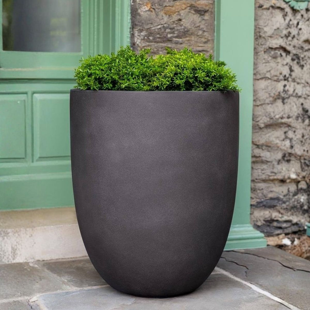 Bradford Planter Extra Large in lead lite color on concrete filled with plants.