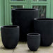 Bradford Planter in onyx black lite on concrete against green door.