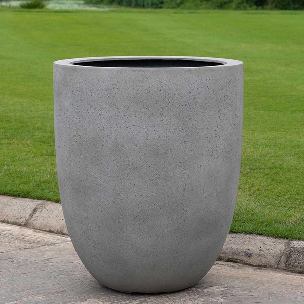 Bradford Planter in stone grey lite on concrete in the backyard.