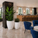 Brannan planters in varying heights in Matte Bright White filled with tropical greenery in a luxury hotel lounge setting