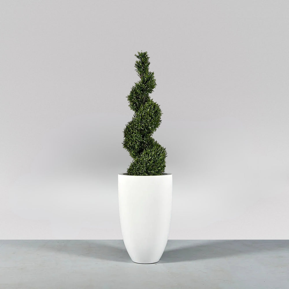 Brannan Tapered Round Fiberglass Planter on concrete filled with plants.