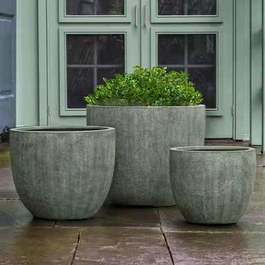 Bromley Planter, Small - Verdigris Lite on concrete filled with plants