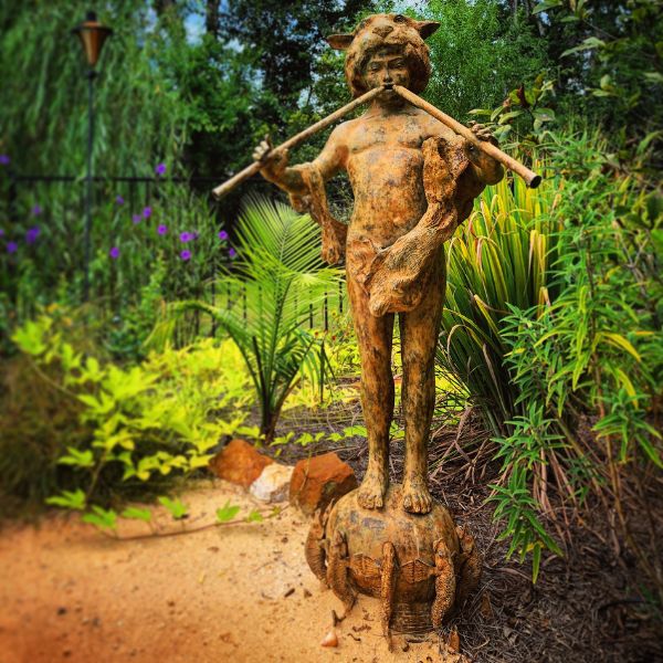 Bronze Boy with pipes on fish base fountain sculpture in the backyard