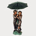 Bronze children holding umbrella fountain against gray background