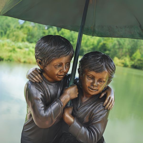 Bronze children holding umbrella fountain upclose