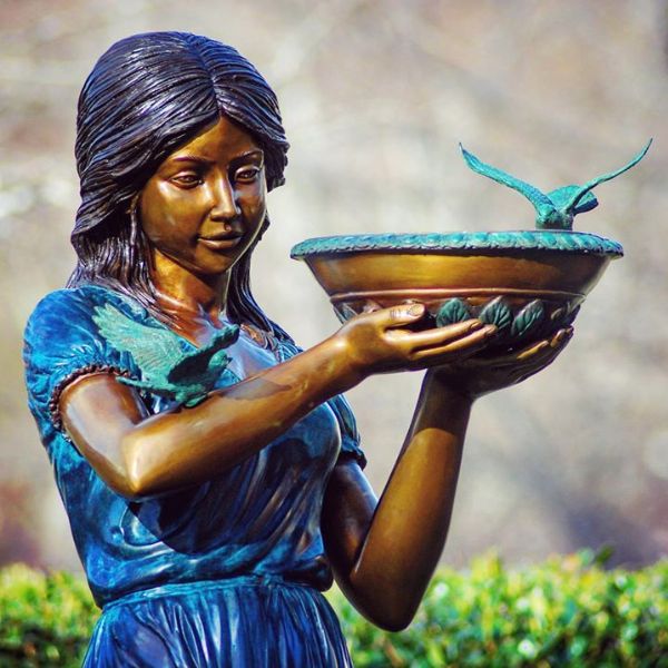 Bronze Girl with birdbath fountain sculpture in the backyard upclose