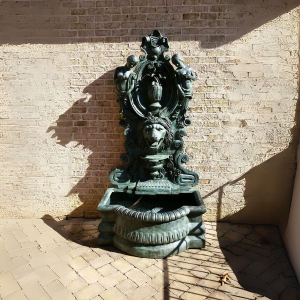 Bronze Lion Head Nymph Wall Fountain on concrete on patio