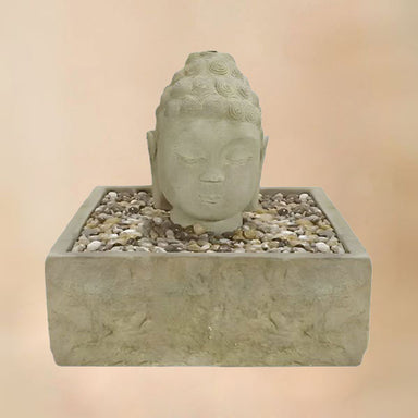 Buddha Head Fountain against brown background.