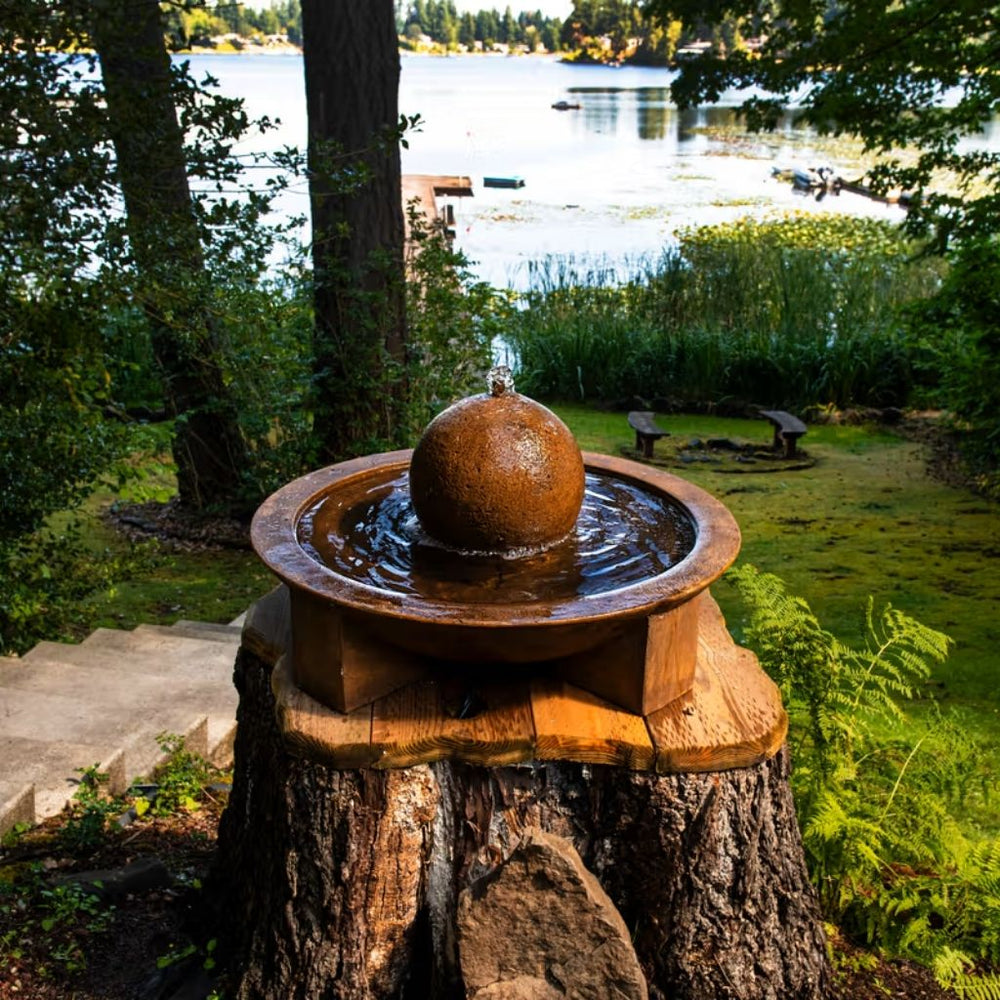 Campania Low Zen Sphere fountain sitting on tree stump in action near lake