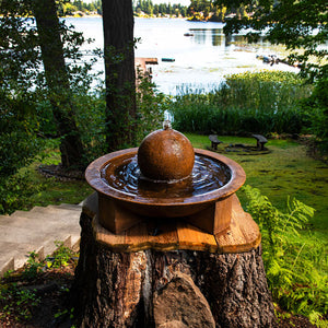 Campania Low Zen Sphere fountain sitting on tree stump in action near lake