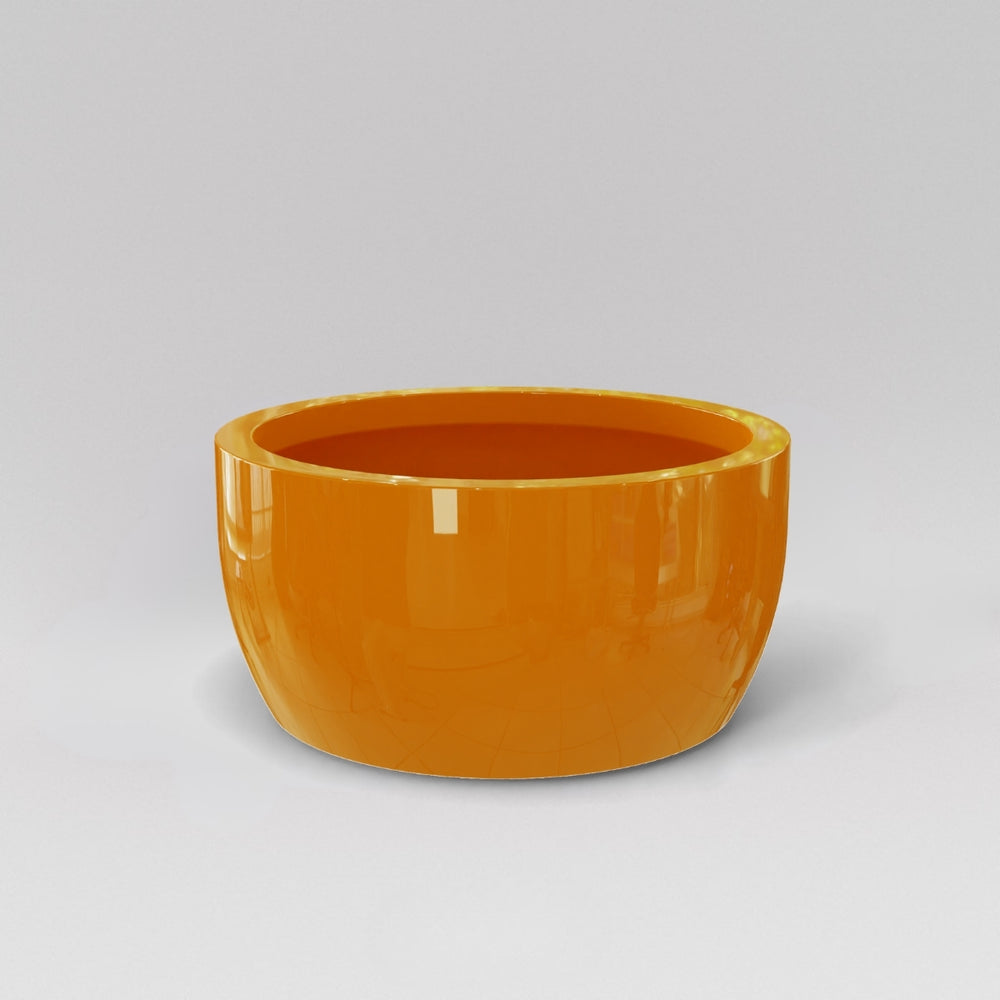 Casablanca Bowl Fiberglass Planter in gloss tangerine against gray background.