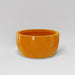 Casablanca Bowl Fiberglass Planter in gloss tangerine against gray background.