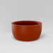 Casablanca Bowl Fiberglass Planter in matte terra cotta against gray background.
