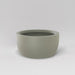 Casablanca Bowl Fiberglass Planter in satin beige against gray background.