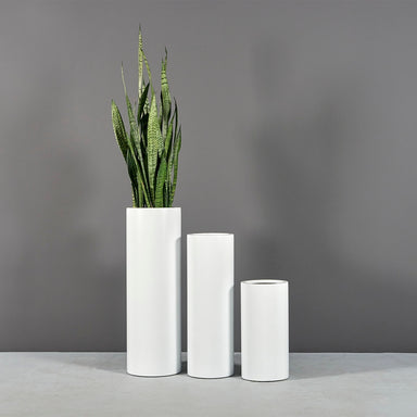 Corry Tall Cylinder Fiberglass Planter shown in different sizes filled with plants.