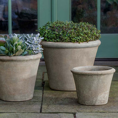 Cortona Planter - Antico Terra Cotta - S/3 on concrete filled with plants