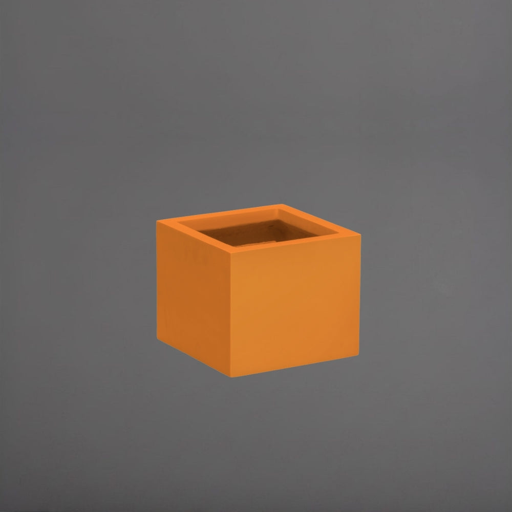 Cuba Low Corner Fiberglass Planter in gloss tangerine against gray background.