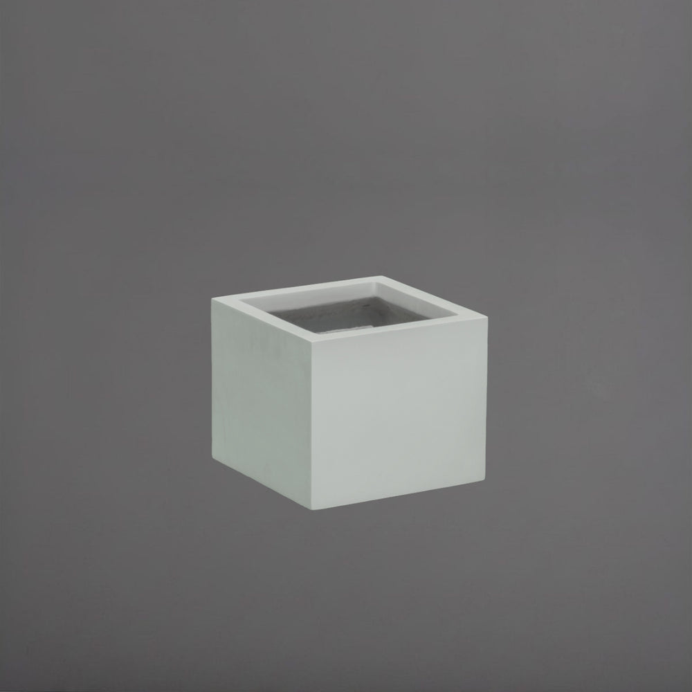 Cuba Low Corner Fiberglass Planter in matte cement grey against gray background.