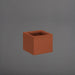 Cuba Low Corner Fiberglass Planter in matte terra cotta against gray background.