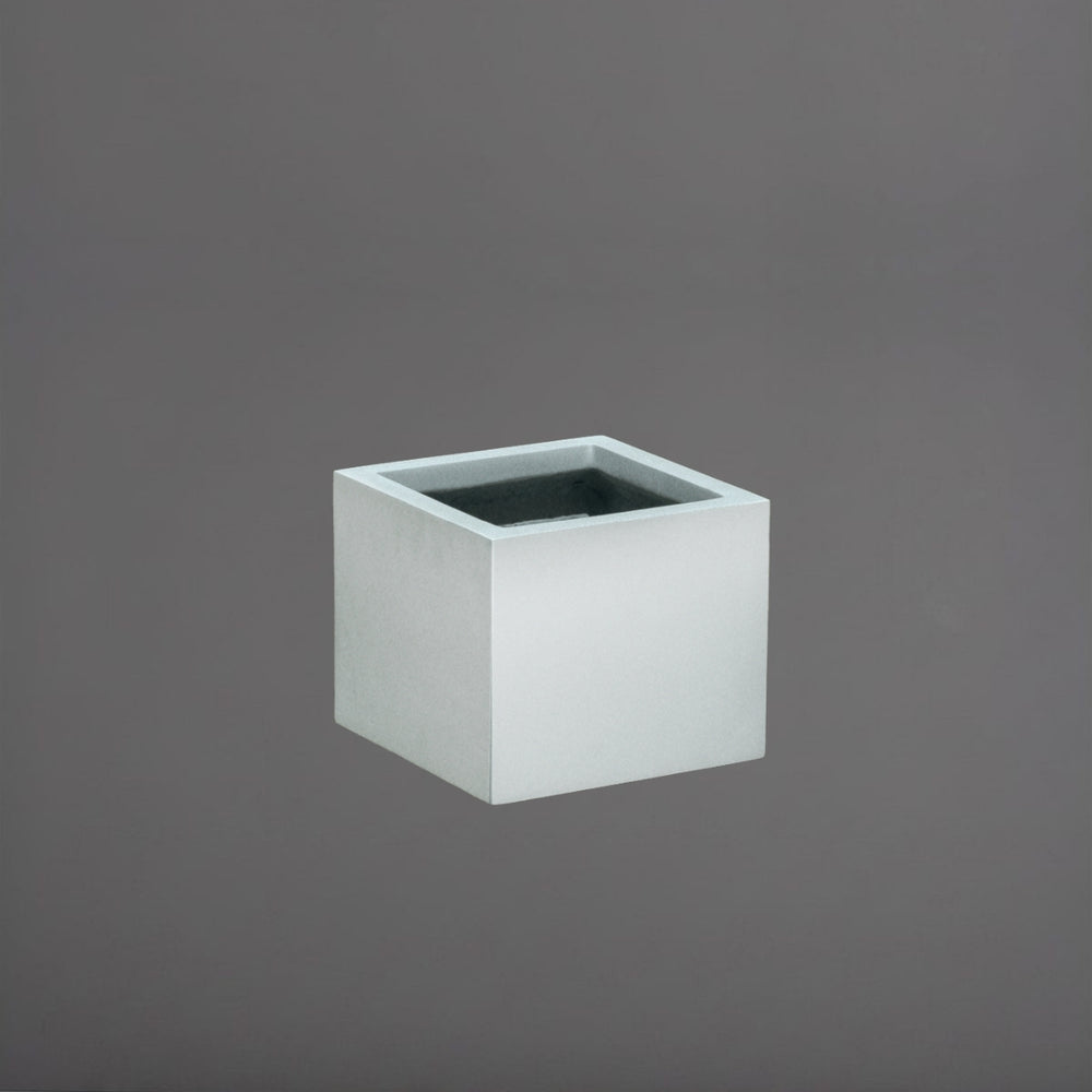Cuba Low Corner Fiberglass Planter in metallic silver against gray background.