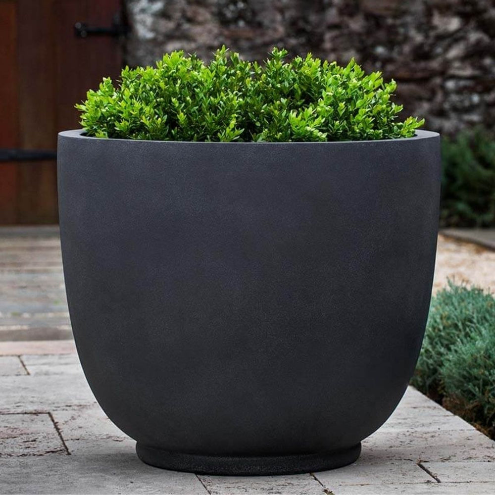 Danilo Planter, Extra Large in lead lite on concrete filled with plants.