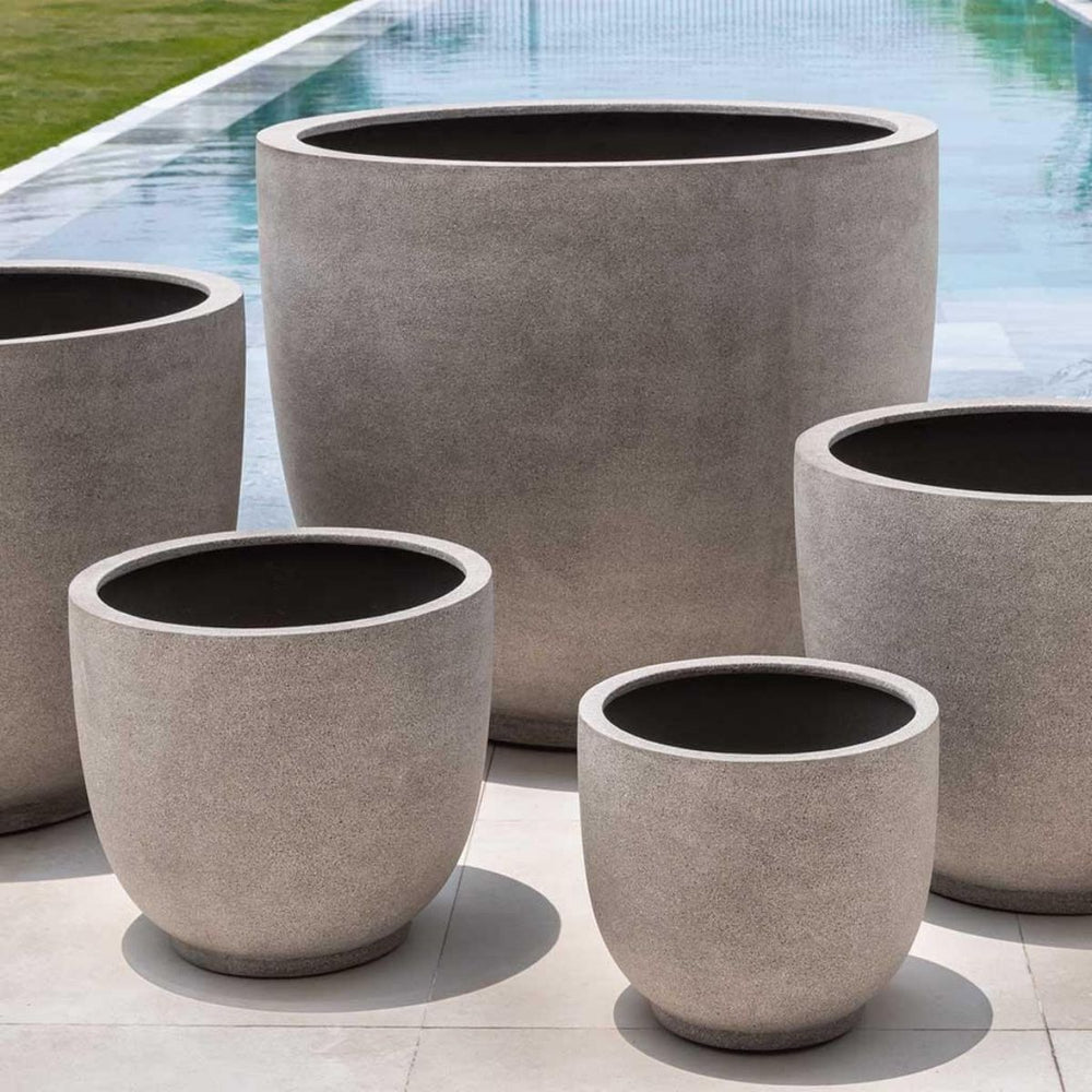 Danilo Planter, Extra Large in riverstone premium lite on concrete near a swimming pool.