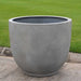 Danilo Planter, Extra Small in stone grey lite on concrete in the backyard.
